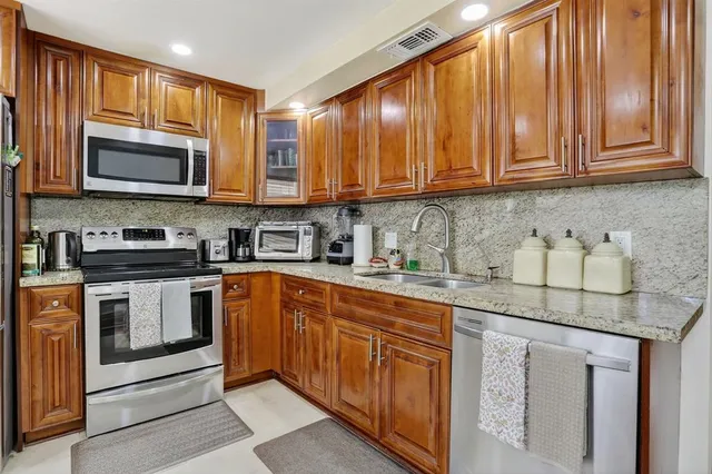a kitchen with stainless steel appliances granite countertop a stove sink microwave and cabinets