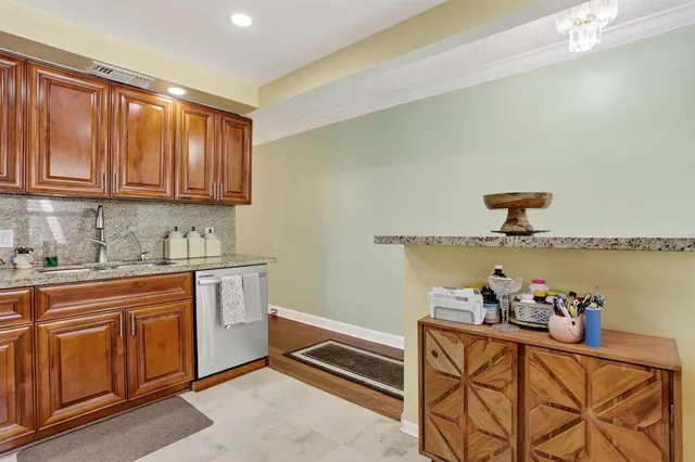 a kitchen with granite countertop white cabinets and stainless steel appliances