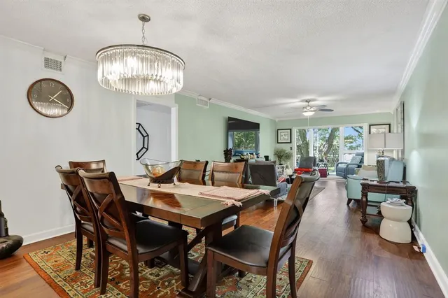 a view of a dining room with furniture wooden floor and chandelier