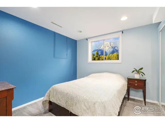 a bedroom with a bed and painting on the wall