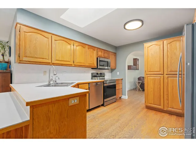 a kitchen with granite countertop a sink stainless steel appliances and cabinets