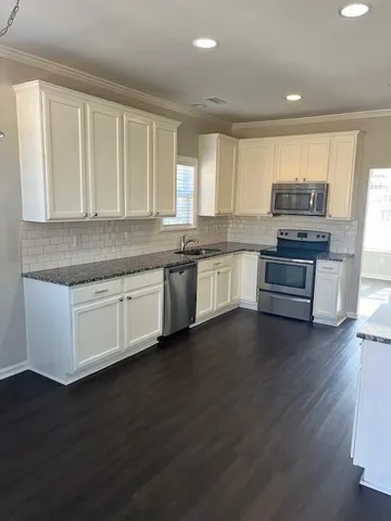 a kitchen with stainless steel appliances granite countertop a stove and cabinets