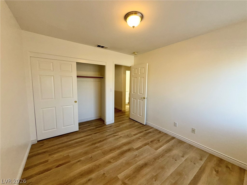 9729 Trail Rider Drive Las Vegas, NV 89117 - Photo 19 of 26 A versatile bedroom featuring durable vinyl plank flooring and an ample closet with sliding doors.