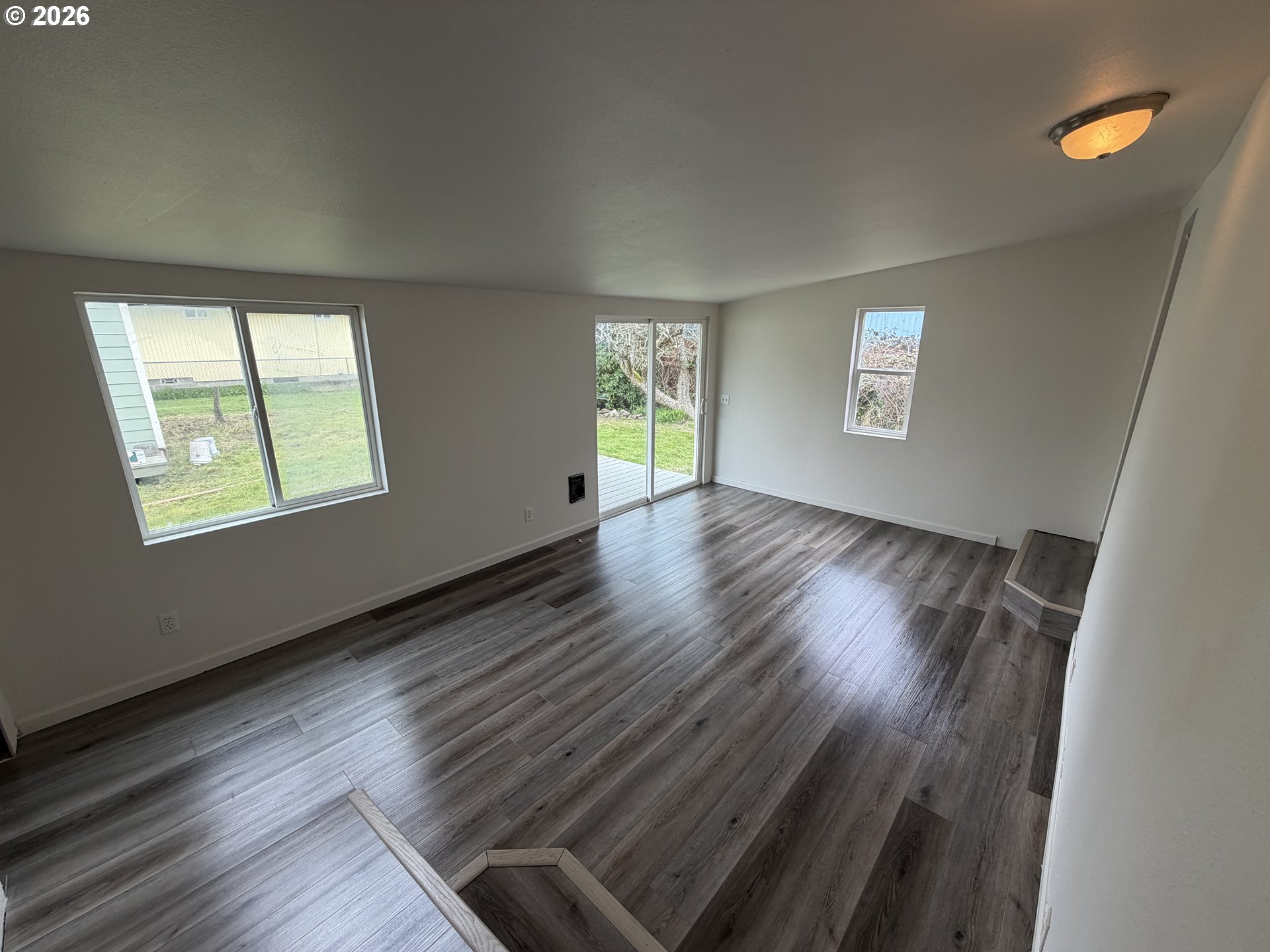 150 South 5th Street Lakeside, OR 97449 - Photo 14 of 19 an empty room with wooden floor and windows