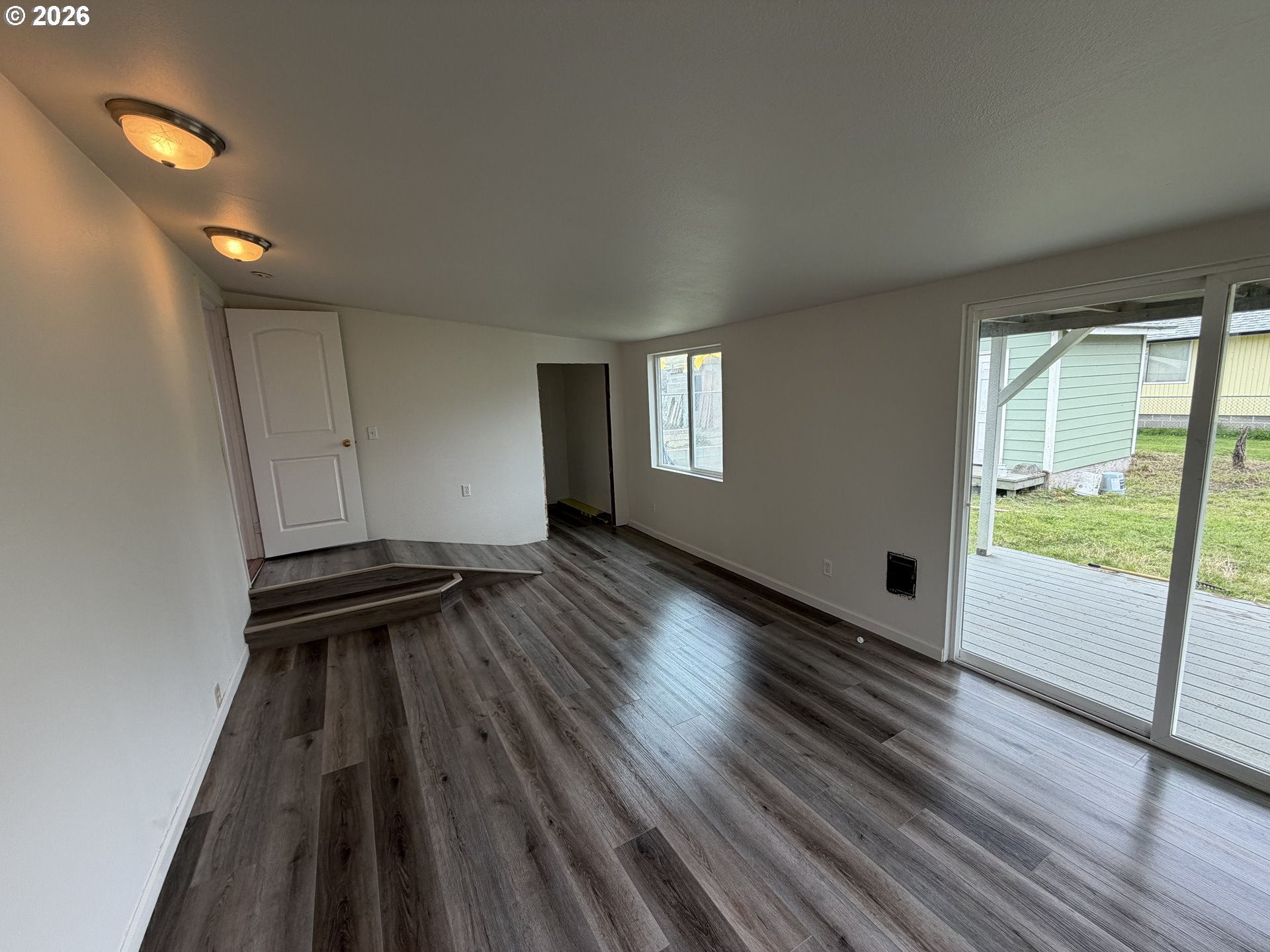150 South 5th Street Lakeside, OR 97449 - Photo 17 of 19 wooden floor in an empty room with a window