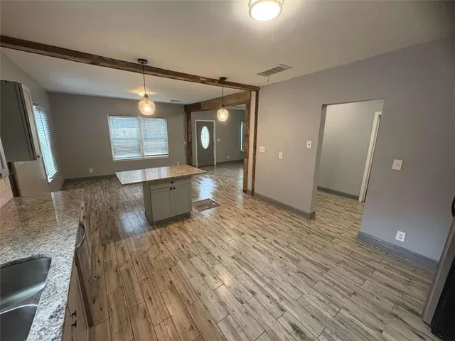 a view of a room with wooden floor and a window