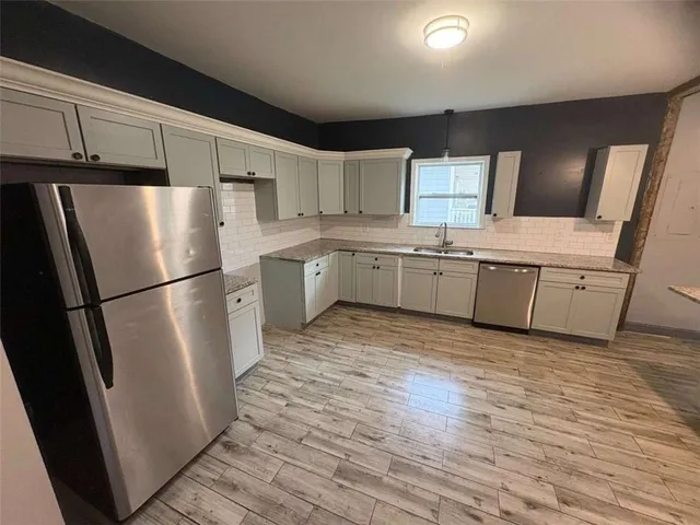 a kitchen with kitchen island granite countertop stainless steel appliances refrigerator sink and microwave