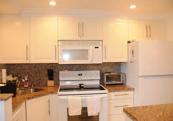 a kitchen with a sink a stove and a microwave