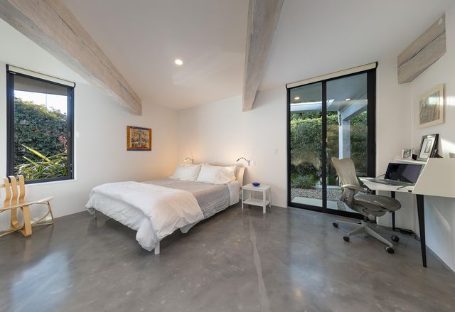 a spacious bedroom with a bed and a large window