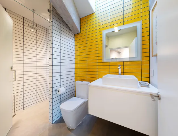 a bathroom with a sink and mirror with toilet