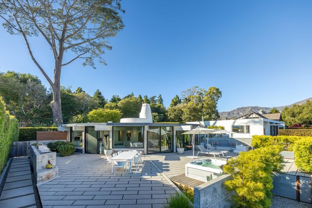 a view of a patio with couches table and chairs and potted plants