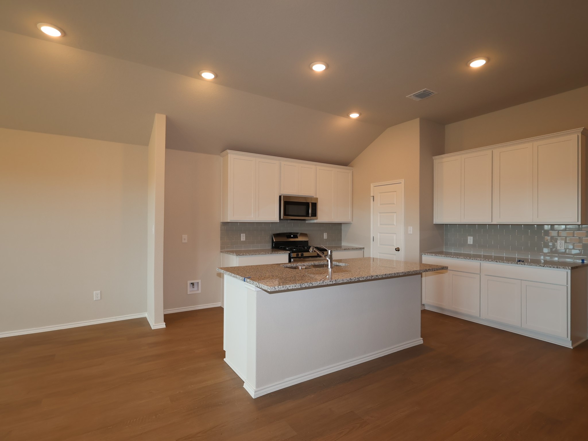 13701 Warnock Trail Manor, TX 78653 - Photo 4 of 22 a kitchen with stainless steel appliances granite countertop a sink and a stove top oven