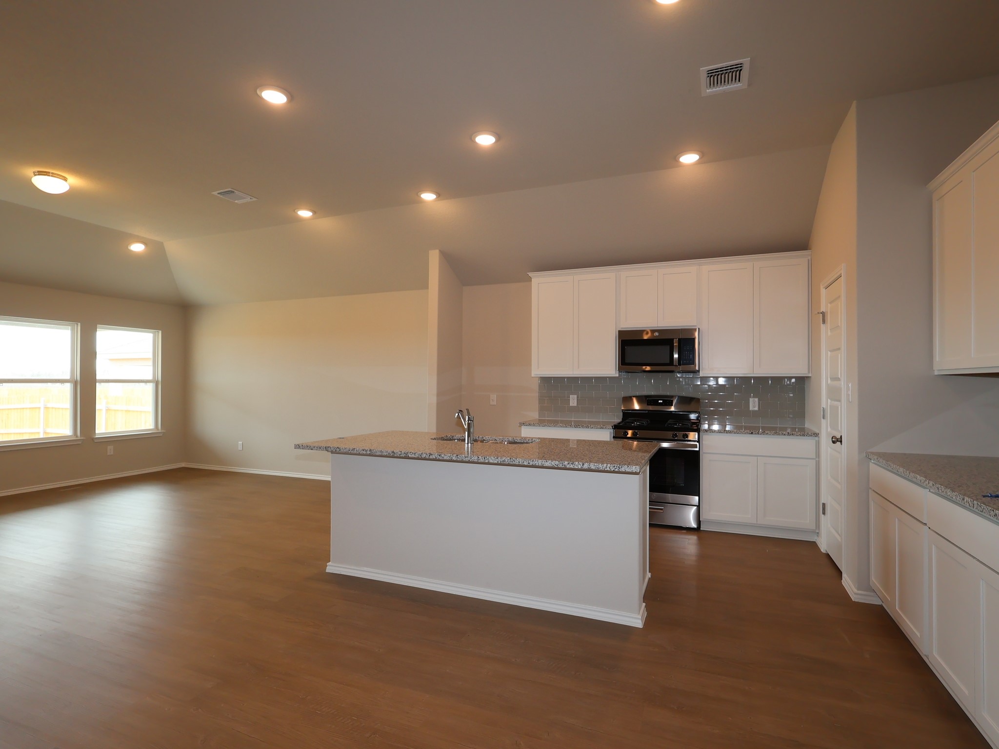 13701 Warnock Trail Manor, TX 78653 - Photo 5 of 22 a kitchen with stainless steel appliances a sink a stove a microwave a center island and a window