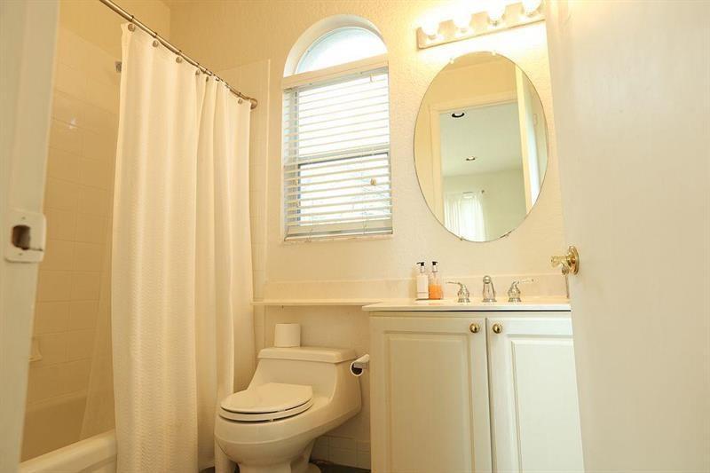 11230 Sea Grass Circle Boca Raton, FL 33498 - Photo 14 of 15 a bathroom with a toilet a sink and a mirror