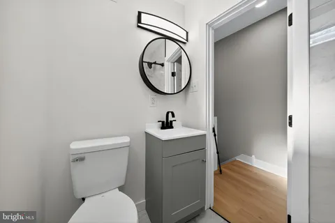 a bathroom with a toilet a sink and a mirror