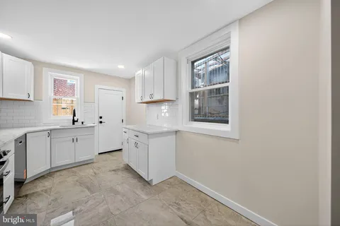 a kitchen with white cabinets and white appliances