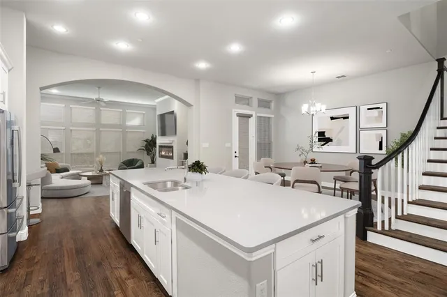 a large white kitchen with a sink and stove