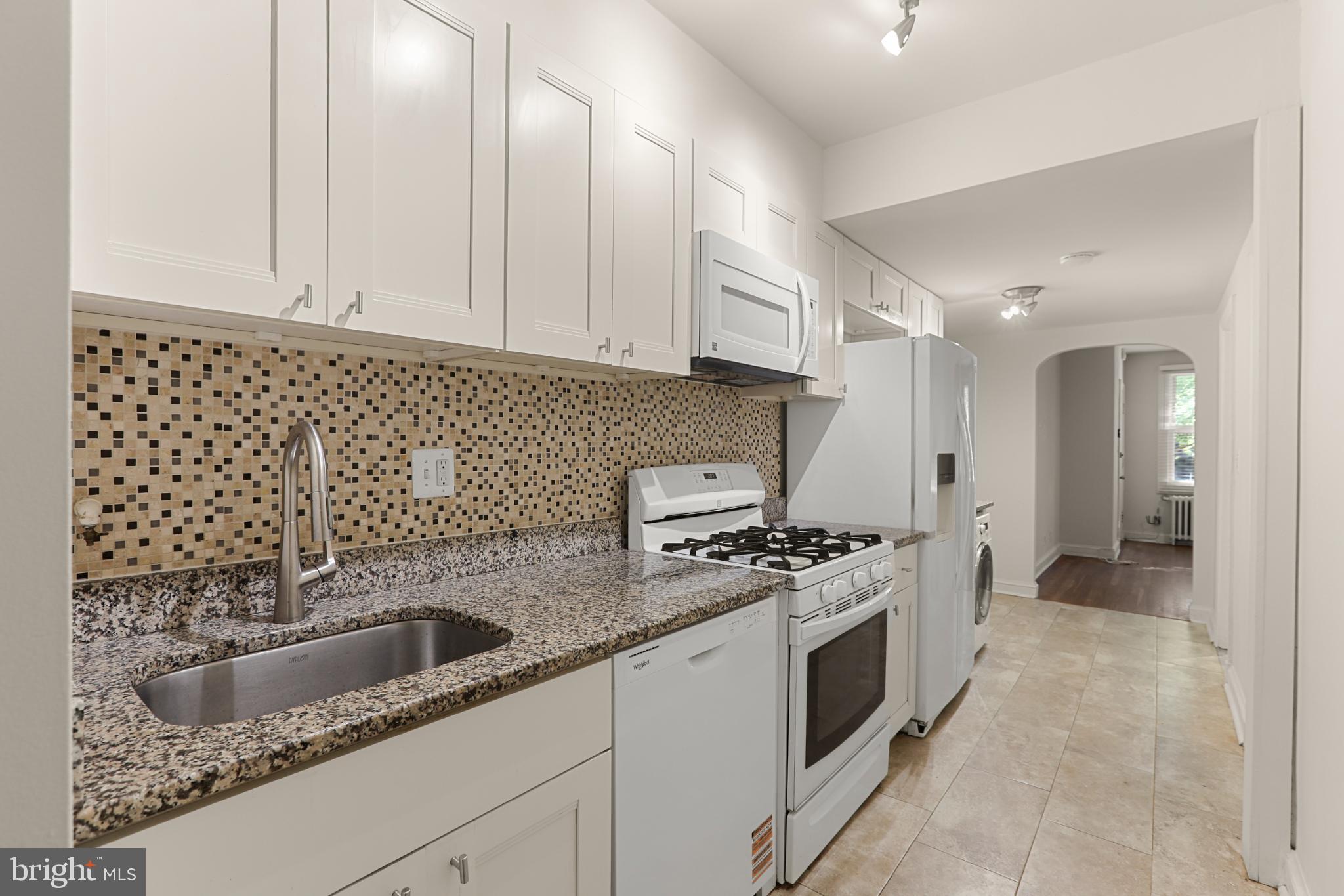 4016 47th Street Northwest, Unit 2 Washington, DC 20016 - Photo 12 of 27 a kitchen with granite countertop a sink a stove and cabinets