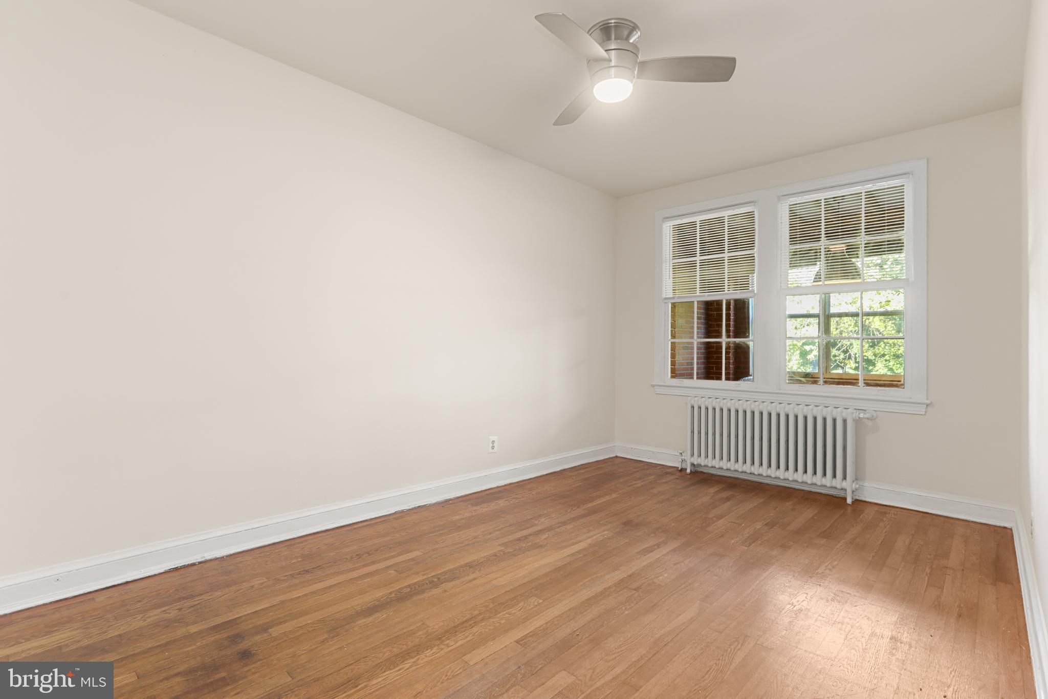 4016 47th Street Northwest, Unit 2 Washington, DC 20016 - Photo 14 of 27 an empty room with wooden floor and windows