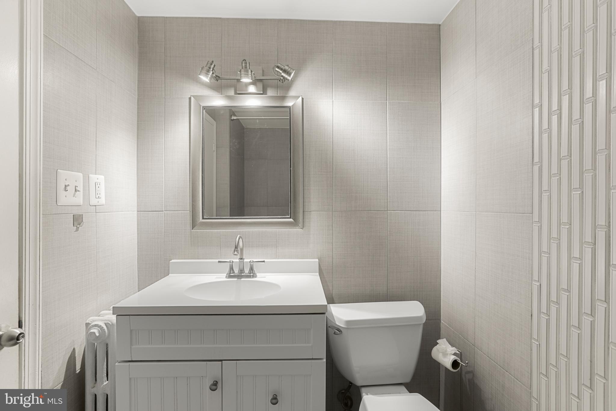 4016 47th Street Northwest, Unit 2 Washington, DC 20016 - Photo 17 of 27 a bathroom with a toilet sink and mirror