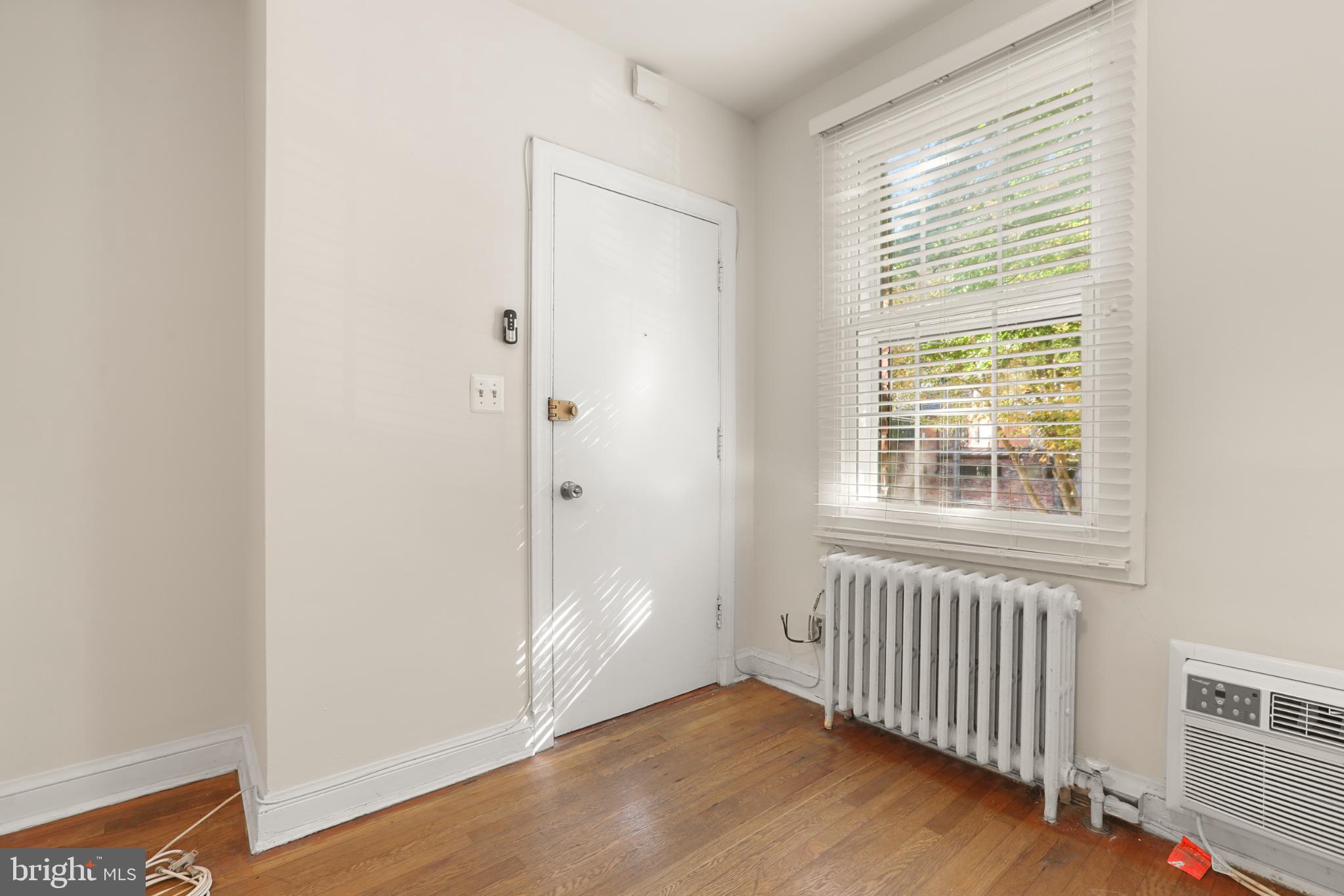 4016 47th Street Northwest, Unit 2 Washington, DC 20016 - Photo 4 of 27 a view of an empty room with wooden floor and a window