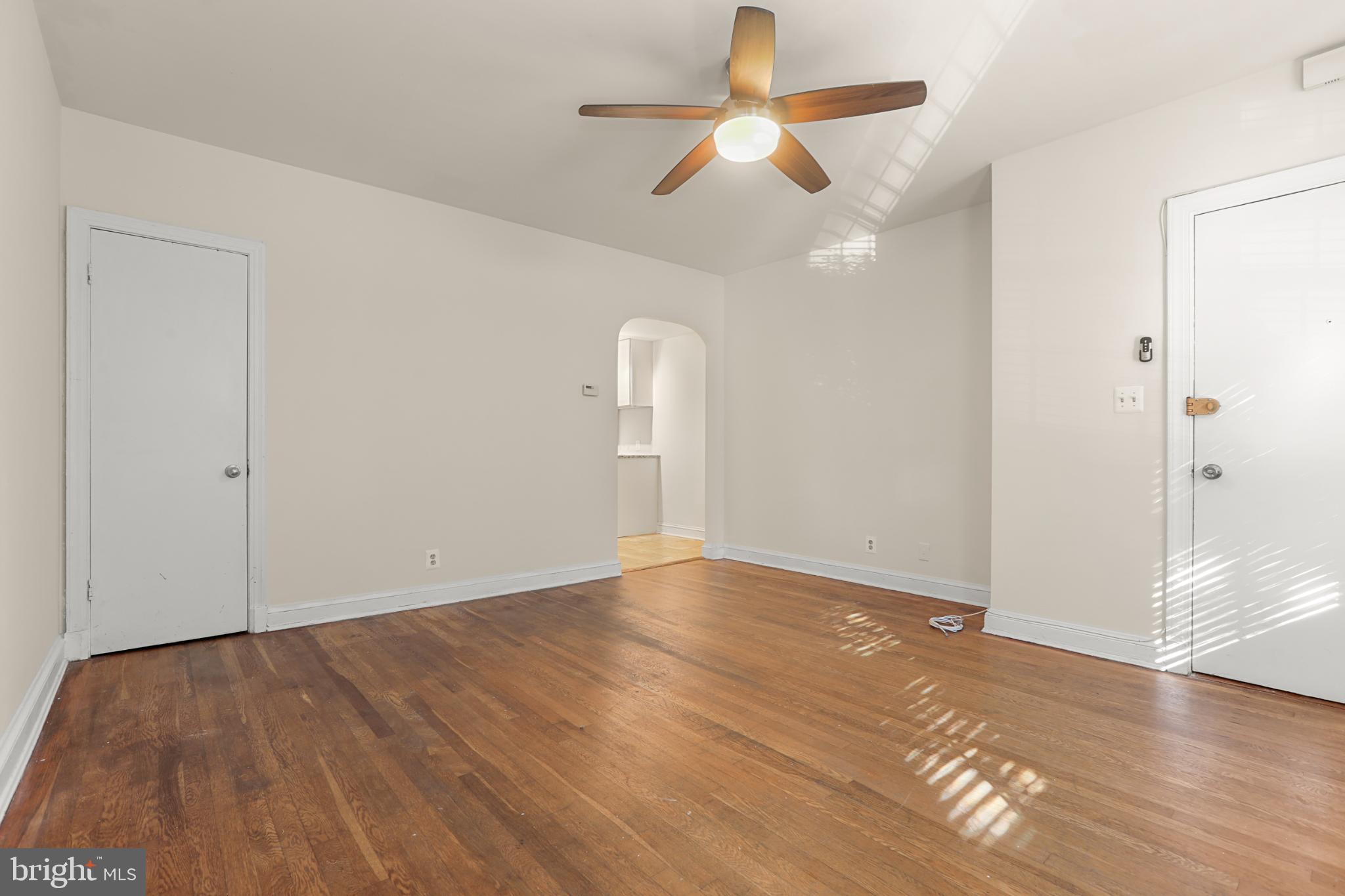 4016 47th Street Northwest, Unit 2 Washington, DC 20016 - Photo 5 of 27 an empty room with wooden floor ceiling fan and windows