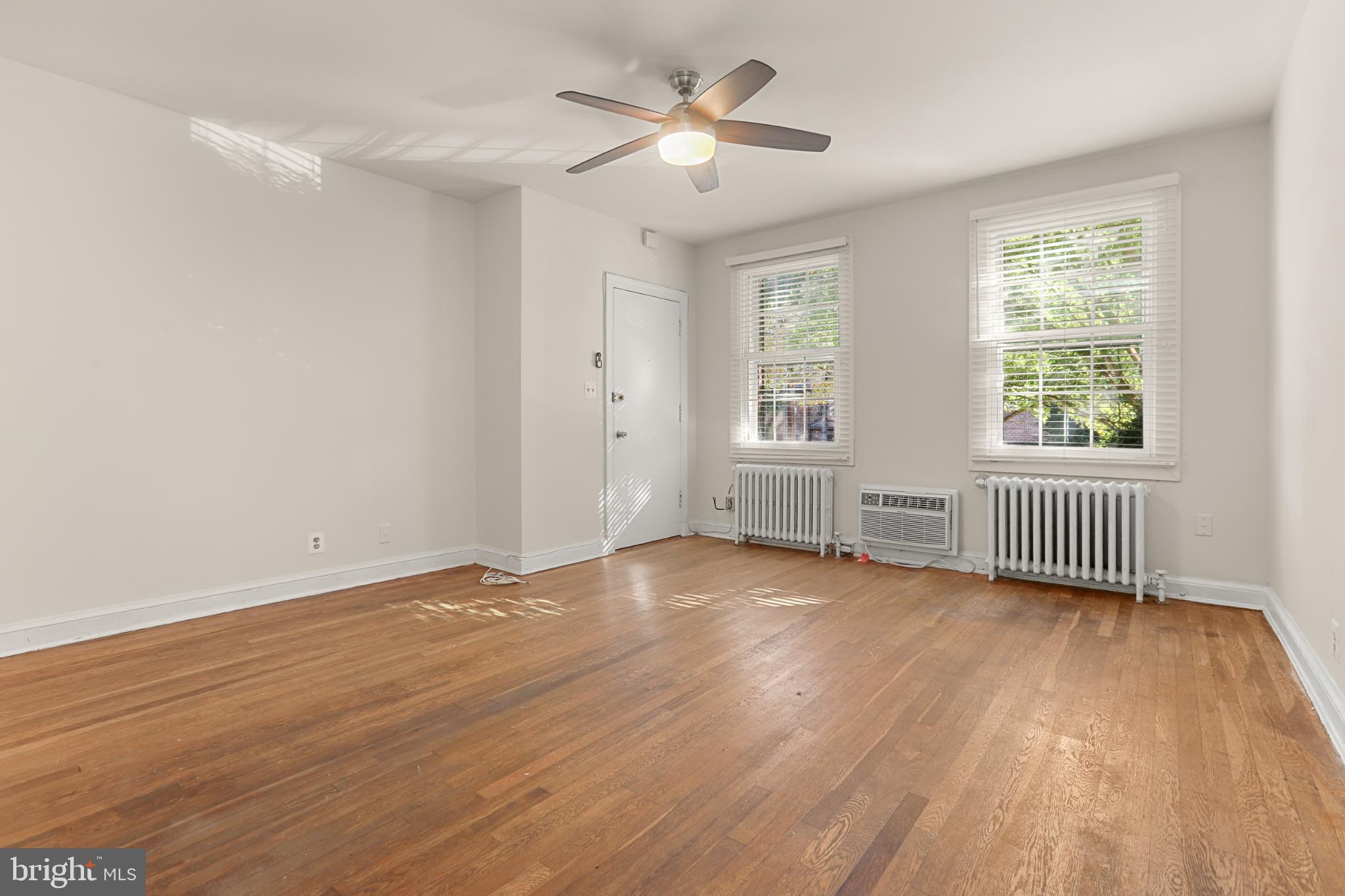 4016 47th Street Northwest, Unit 2 Washington, DC 20016 - Photo 6 of 27 a view of an empty room with a window and wooden floor