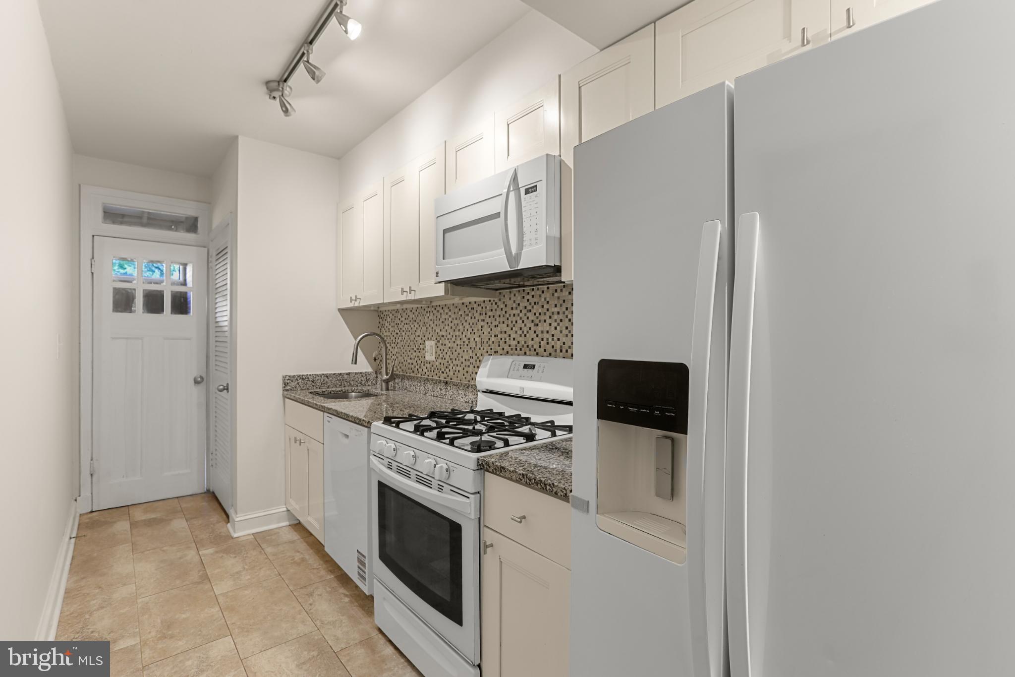 4016 47th Street Northwest, Unit 2 Washington, DC 20016 - Photo 10 of 27 a kitchen with stainless steel appliances granite countertop a refrigerator and a stove