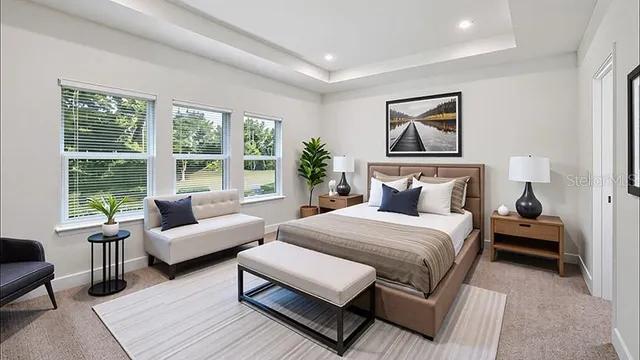 a bedroom with a bed a couch and a large window