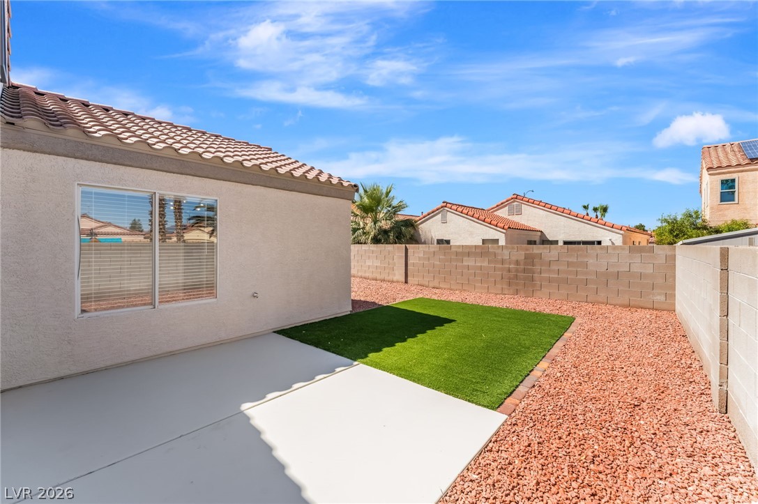 668 Rising Brook Drive Henderson, NV 89011 - Photo 19 of 22 A low-maintenance backyard retreat featuring artificial turf, decorative rock, and a spacious concrete patio.