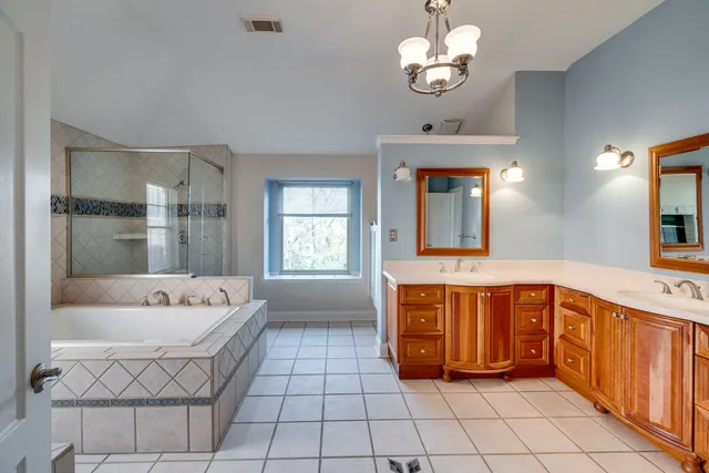 a spacious bathroom with a tub sink and mirror
