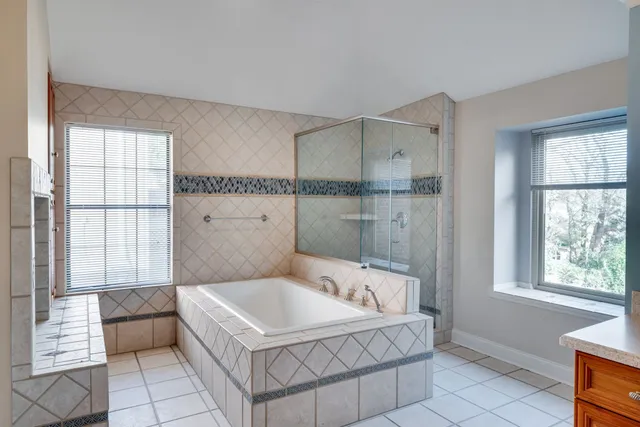 a spacious bathroom with a tub shower and window