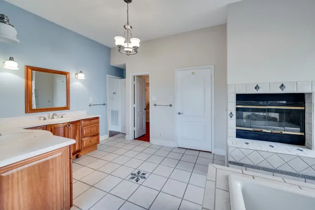 a view of an empty room with a fireplace and a chandelier