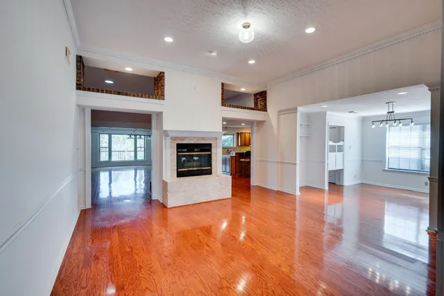 a view of a big room with wooden floor and a kitchen