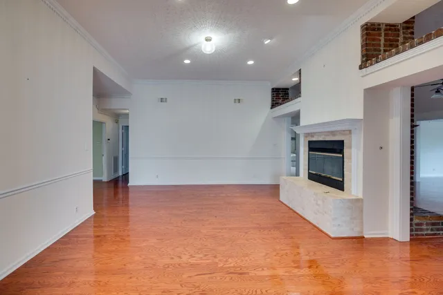 an empty room with wooden floor and fireplace