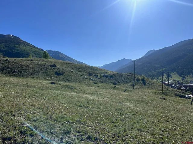 a view of a dry yard with mountains in the background