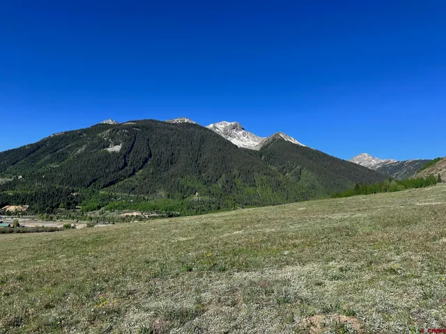 a view of mountains with green yard