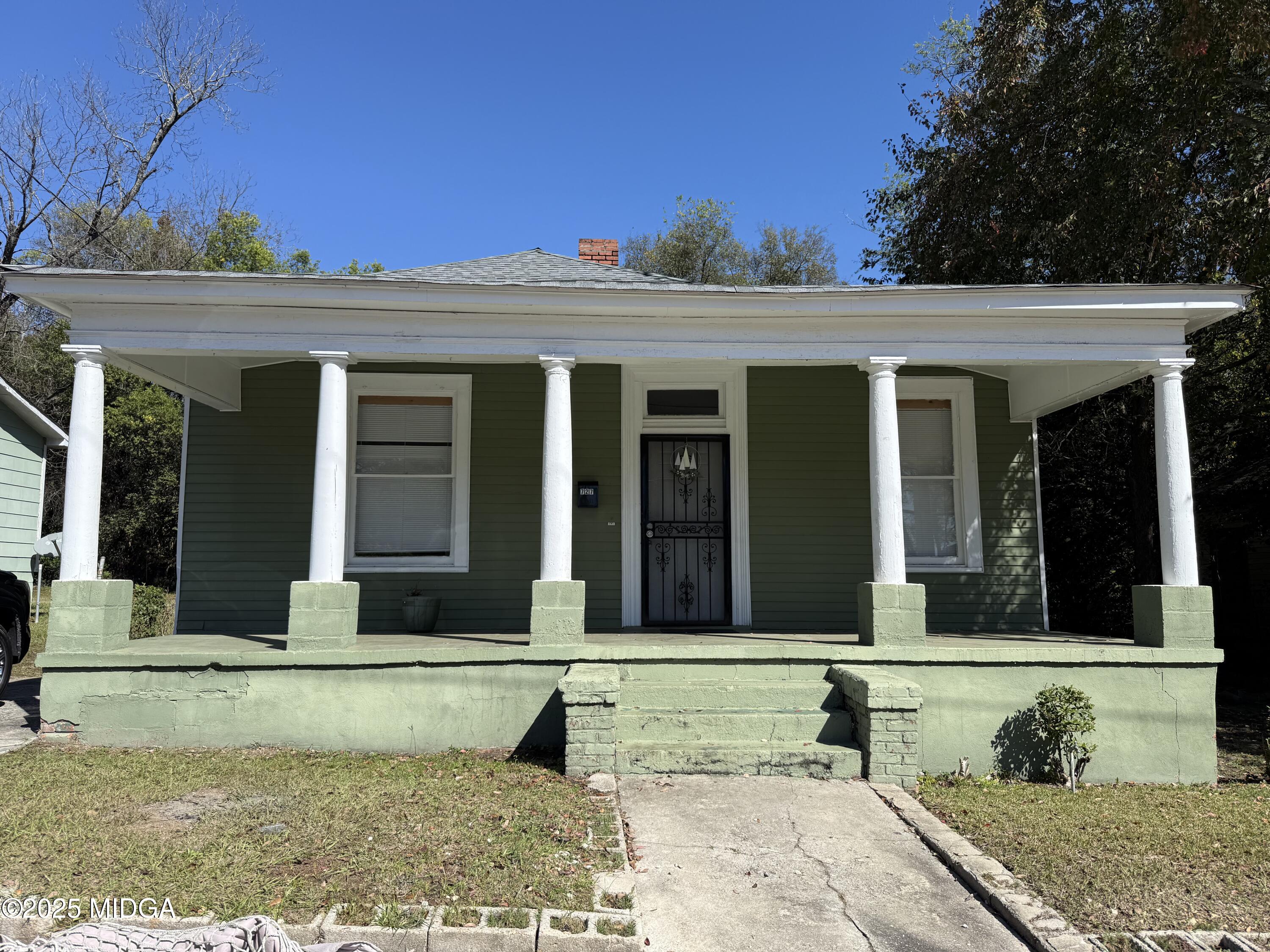 a view of a brick house with potted plants