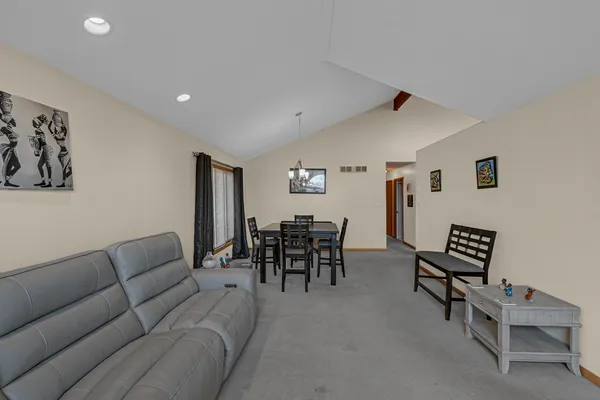 a living room with furniture and a dining table with chair