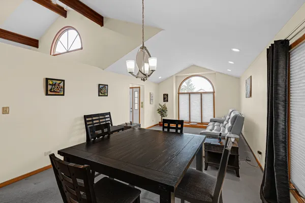 a view of a dining room with furniture and a chandelier