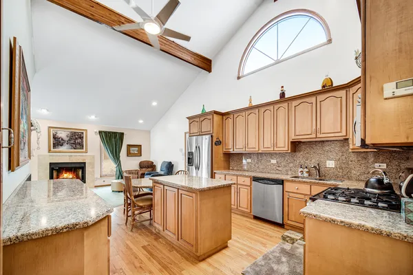 a kitchen with stainless steel appliances granite countertop a sink dishwasher stove top oven and cabinets with wooden floor
