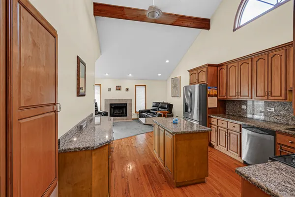 a kitchen with stainless steel appliances granite countertop a refrigerator a stove top oven a sink and dishwasher