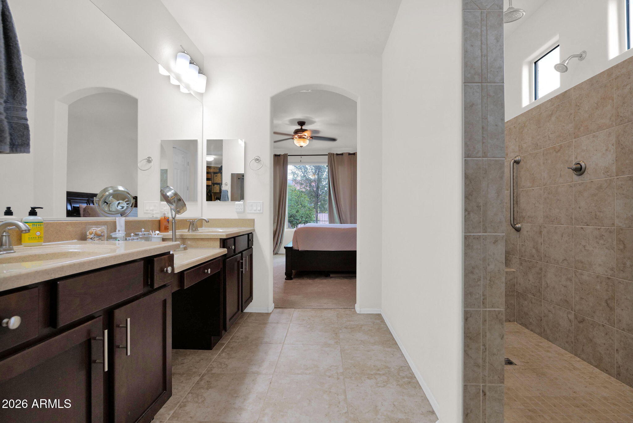 7438 West Noble Prairie Way Florence, AZ 85132 - Photo 19 of 38 a en suite bathroom with a double vanity sink a mirror and a bathtub
