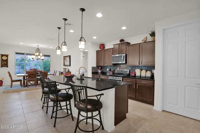 a kitchen that has a lot of cabinets and stainless steel appliances