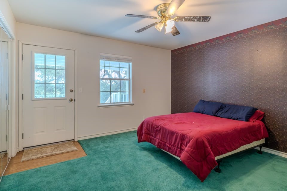 483 Riverside Drive Palacios, TX 77465 - Photo 18 of 41 a bedroom with a bed and a chandelier