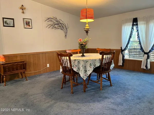 a view of a dining room with furniture and a chandelier