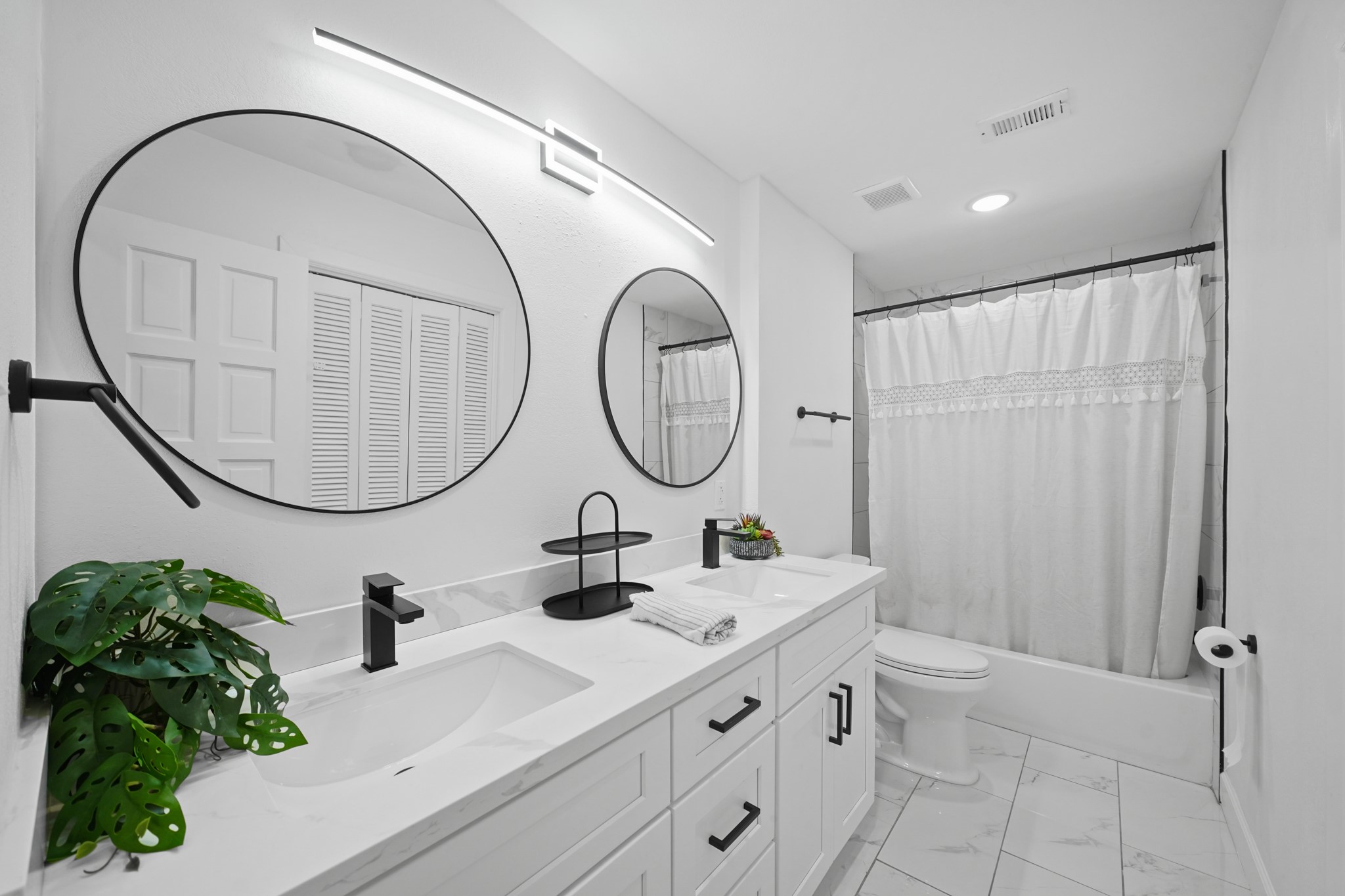 10031 Inwood Drive Houston, TX 77042 - Photo 23 of 31 a bathroom with a double vanity sink and a mirror