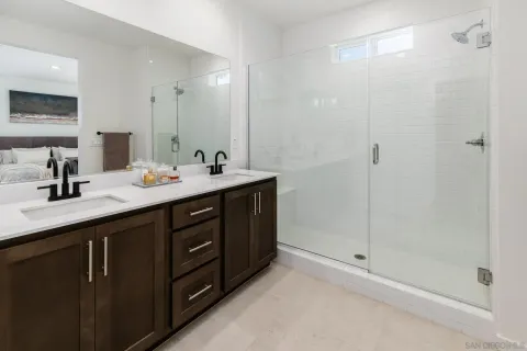 a bathroom with a double vanity sink mirror and shower
