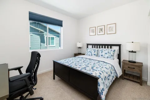 a bedroom with a bed chair and a window