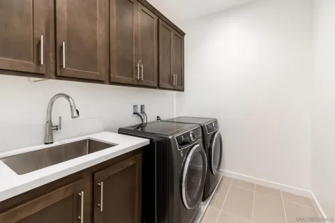 a utility room with sink dryer and washer